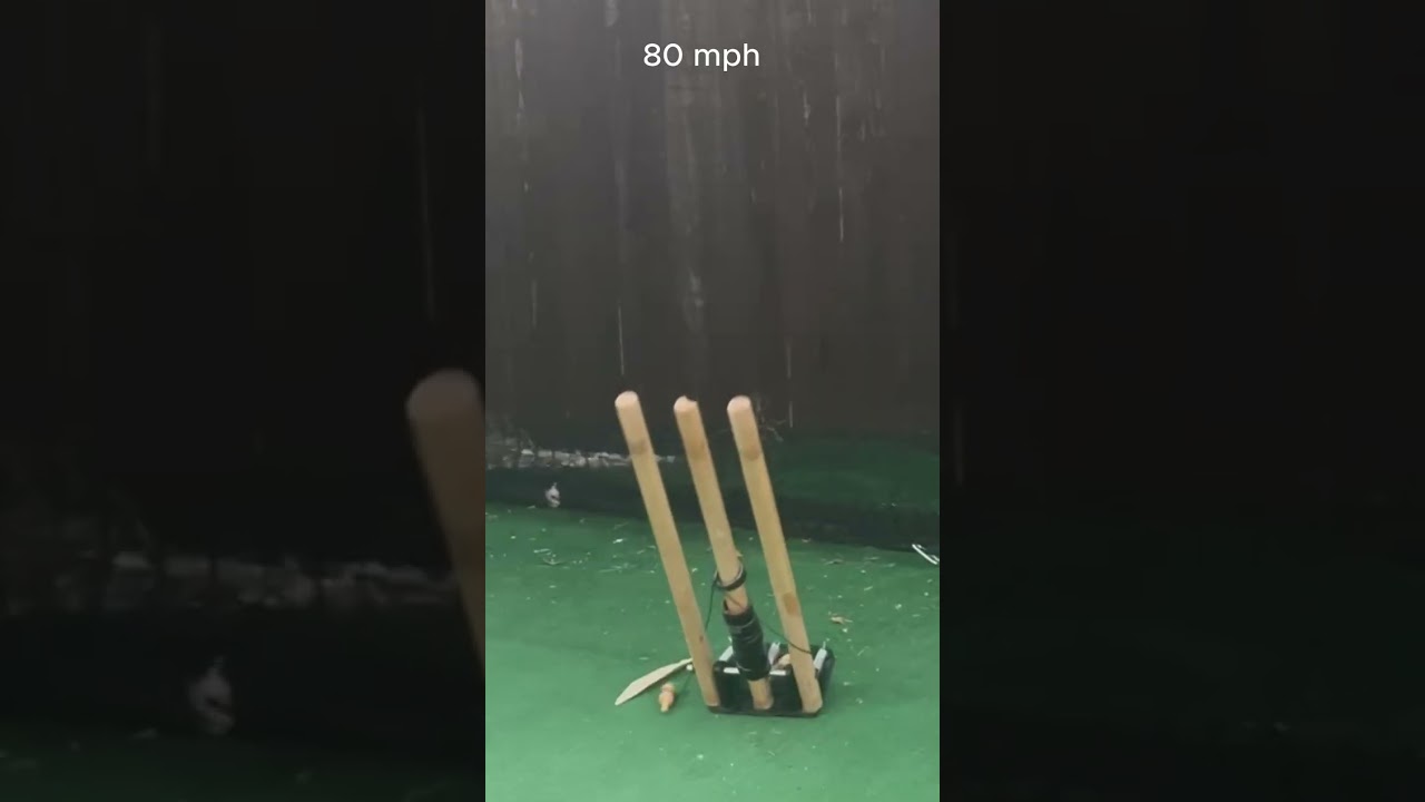Still from the impact test video: a set of stumps in an indoor net, captioned 80 mph.